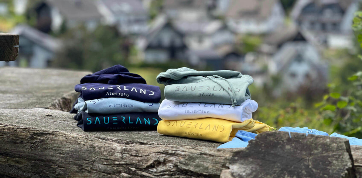 newSAUERLAND Hoodies liegen vor der schönen Sauerländer Natur