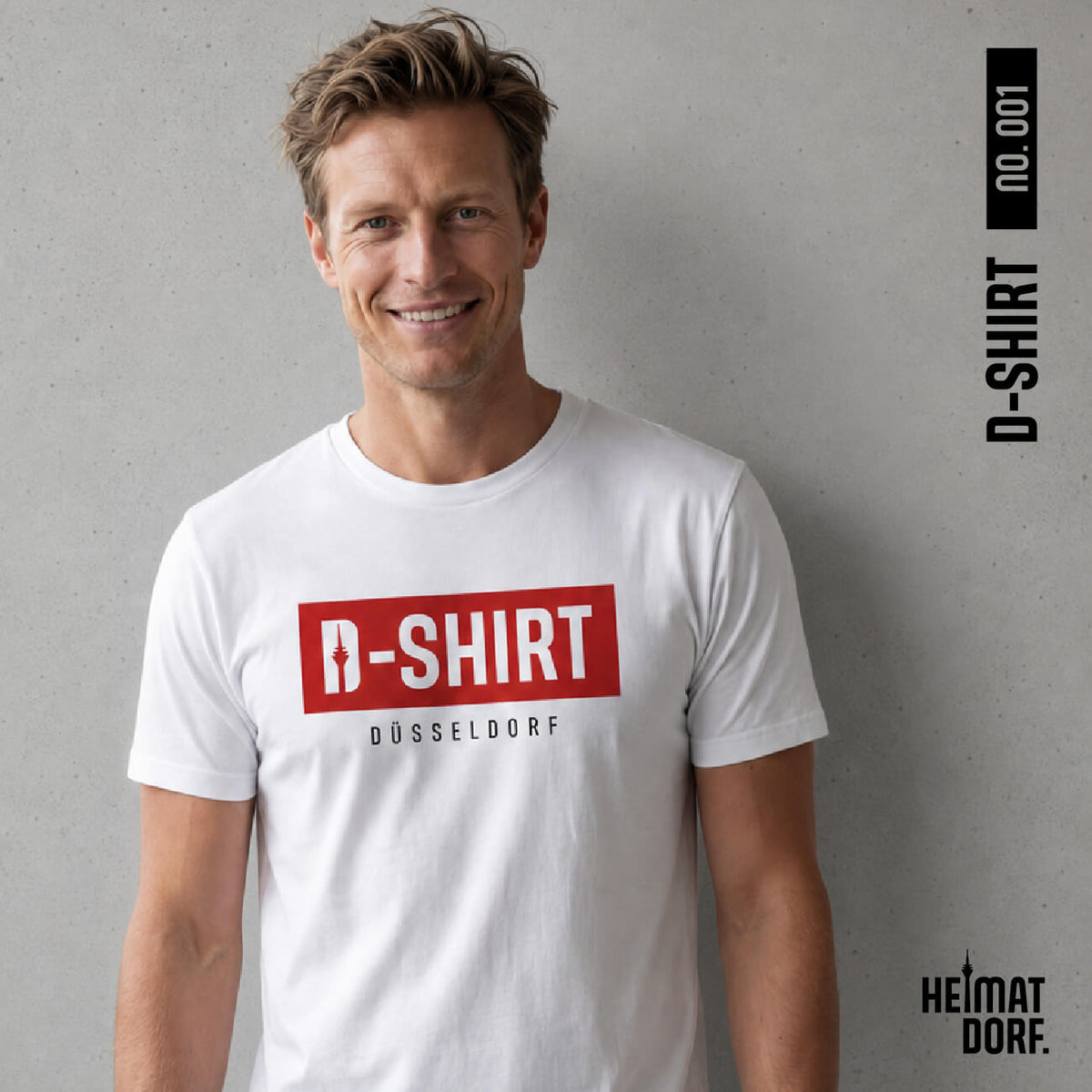 Mann steht in einem weißen Düsseldorf T-Shirt vor einer grauen Wand. Auf dem Shirt ist ein roter Balken mit dem weißen Aufdruck D-Shirt. Im D befindet sich einer Grafik des Rheinturms. Unter der roten Box steht in schwarz der Stadtname Düsseldorf.