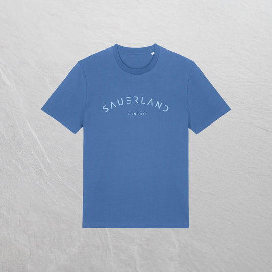 Mittelblaues T-Shirt mit leicht gerundetem Sauerland-Schriftzug liegt auf einem Holzhintergrund. In der Mitte unter dem Sauerland-Schriftzug ist der Dorfname Kierspe eingedruckt. Der Aufdruck ist hellblau.