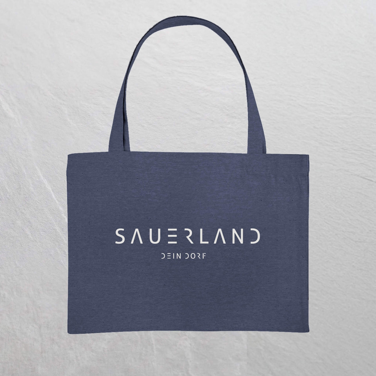 Dunkelblaue  Baumwolltasche mit weißem Sauerland Logo bedruckt. Der moderne Schriftzug wird darunter mit dem Dorfnamen ergänzt. 