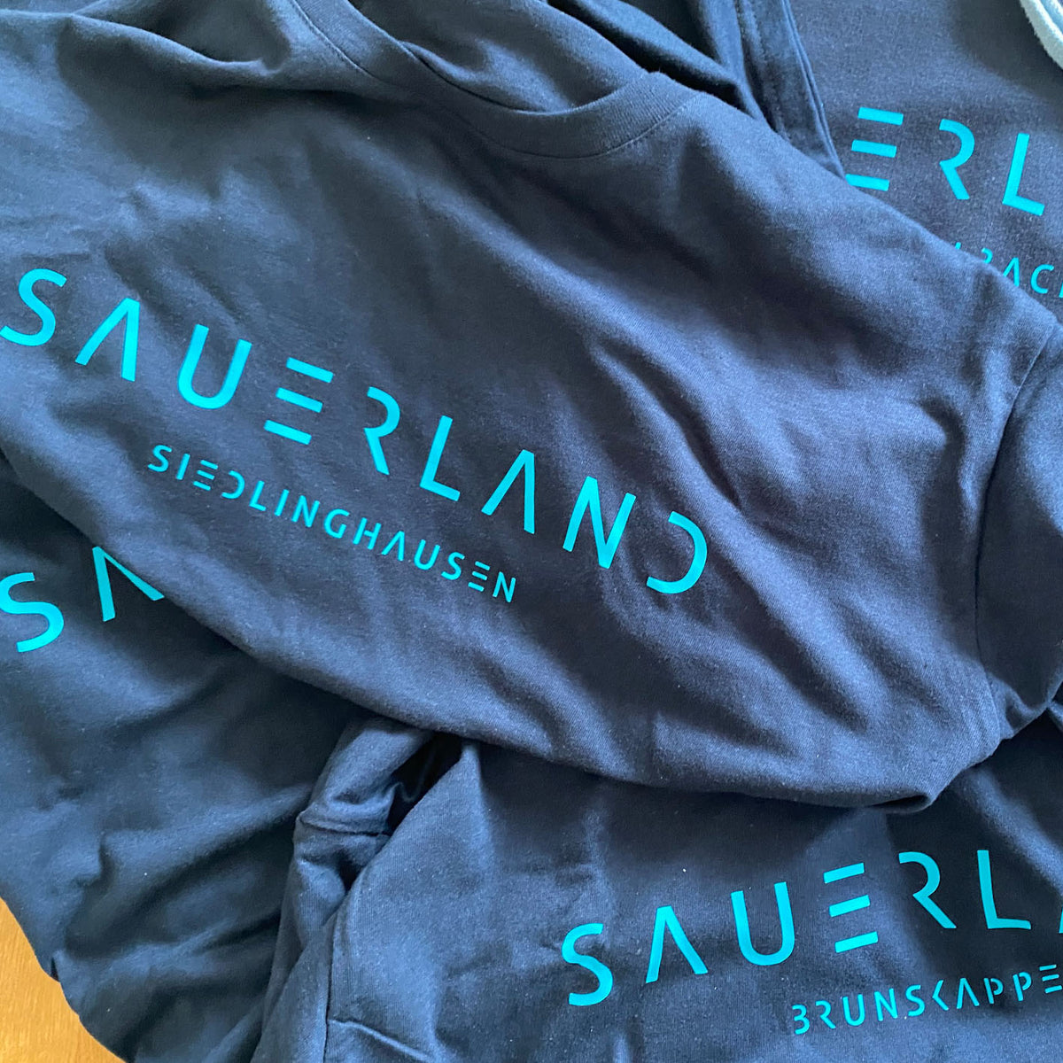 Viele newSAUERLAND Hoodies in dunkelblau übereinander