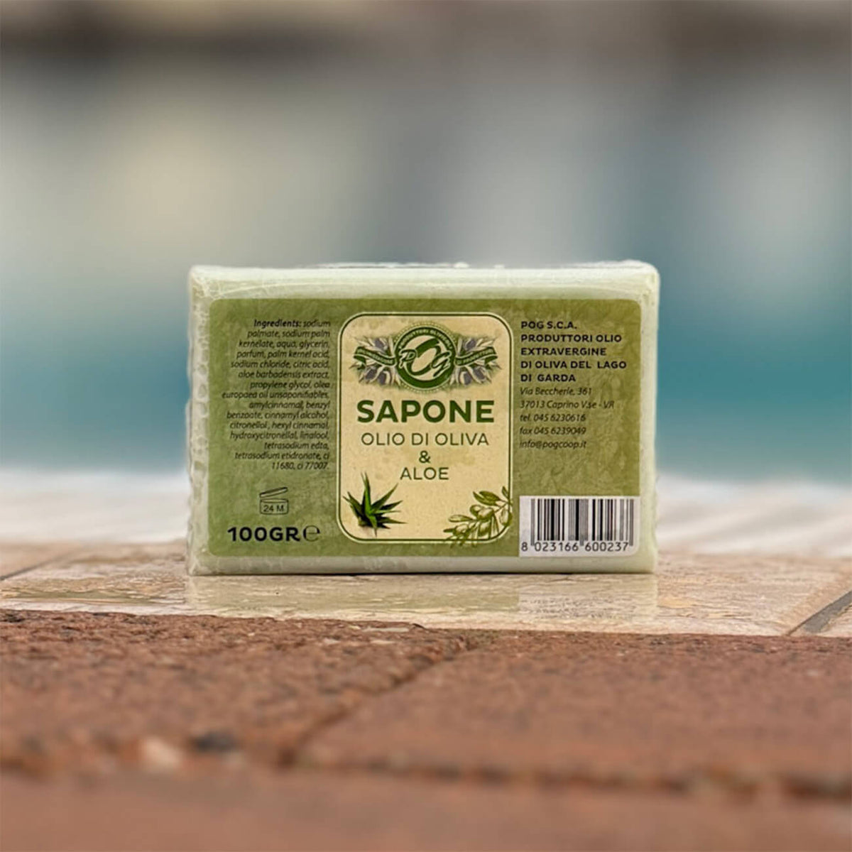 Seifenstück aus Olivenöl und Aloe steht auf dem Rand eines Pools