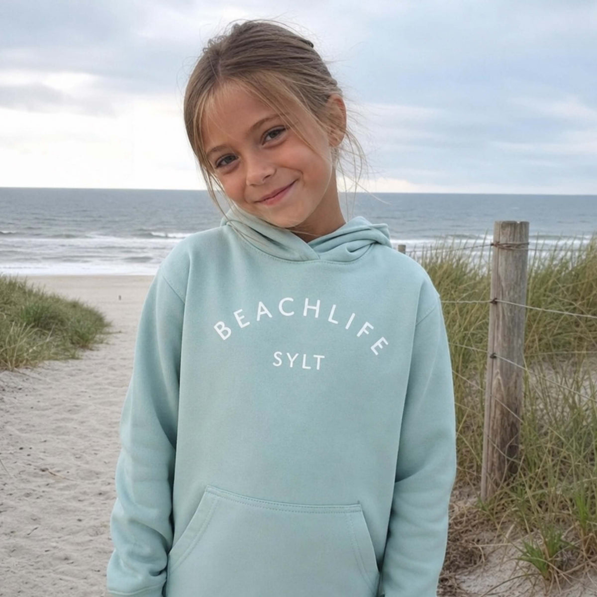 Kind am Strand mit aqua farbenden BEACHLIFE Hoodie auf Sylt