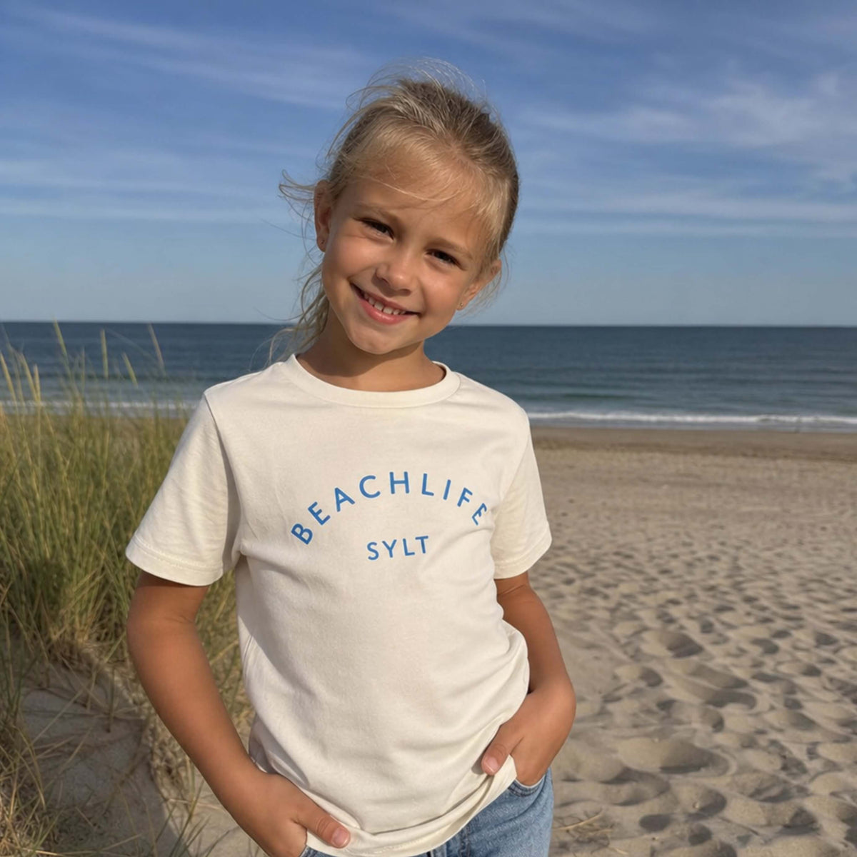 Weisses Kinder T-Shirt mit blauem Aufdruck Beachlife Sylt.