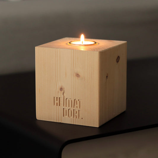 Düsseldorf Kerzenhalteraus Holz in Wrfelform mit Fräsung "HeimatDorf" auf der Vorderseite.